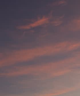 Un cielo pieno di nuvole colorate durante il tramonto, con sfumature di rosa e blu. - Olive Oil Times