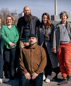 Eine Gruppe von sechs Personen posiert gemeinsam im Freien in der Nähe eines Gewässers. - Olive Oil Times