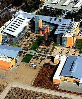 Vue aérienne d'un complexe immobilier moderne avec jardins paysagers et structures multiples. - Olive Oil Times