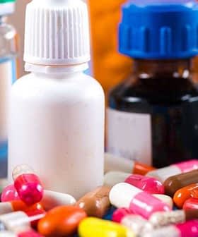 Diversos frascos farmacéuticos y cápsulas de colores dispuestos sobre una superficie. - Olive Oil Times