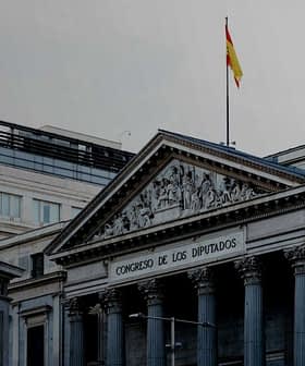 Здание Конгресса депутатов в Испании со статуей перед ним и флагом наверху. - Olive Oil Times