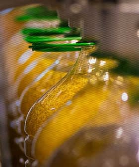 生産ラインでオリーブオイルのボトルが充填され、キャップが付けられています。 - Olive Oil Times