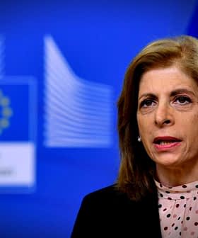 Um funcionário da Comissão Europeia falando durante uma coletiva de imprensa com um fundo azul e a bandeira da UE. - Olive Oil Times