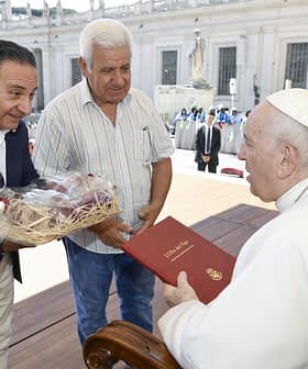 Twee mannen overhandigen geschenken aan paus Franciscus tijdens een ontmoeting in het Vaticaan. Olive Oil Times