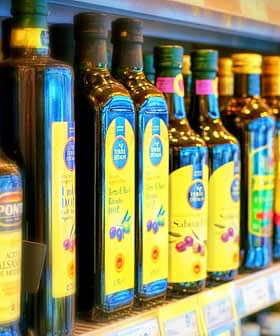 食料品店の棚に並べられた様々なオリーブオイルのボトル。 - Olive Oil Times