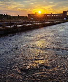 Estação de tratamento de água com vista para o pôr do sol refletido na superfície da água. - Olive Oil Times
