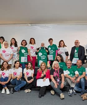 Un gruppo di persone posa insieme all'evento Race for the Cure a Roma, indossando magliette abbinate. - Olive Oil Times