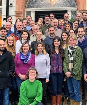 Un folto gruppo di persone posa insieme per una foto all'esterno di un edificio. - Olive Oil Times