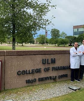 白衣を着た 5 人のグループが ULM 薬学部の看板の前に立っています。 - Olive Oil Times