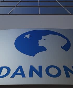 Логотип компанії Danone на фасаді будівлі з синім силуетом профілю дитини. - Olive Oil Times