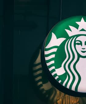 Panneau avec logo Starbucks sur fond vert et emblème de sirène blanche avec une couronne. - Olive Oil Times