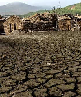 Gebarsten, droge aarde met resten van stenen gebouwen in een desolaat landschap. Olive Oil Times