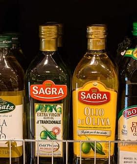 Verschiedene Flaschen mit nativem Olivenöl extra, unter anderem der Marken Sagra und Fragata, stehen auf einem Regal. - Olive Oil Times