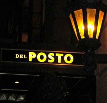 Panneau lumineux indiquant « Del Posto » avec une lanterne au-dessus. - Olive Oil Times