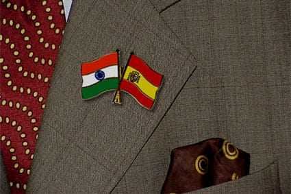 Lapel pins featuring the flags of India and Spain attached to a suit jacket. - Olive Oil Times