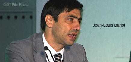 Jean-Louis Barjol speaking at a conference, wearing a suit and tie. - Olive Oil Times