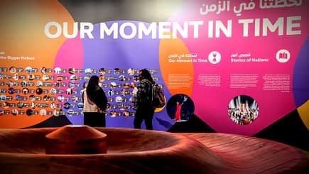 Colorful exhibition display featuring the phrase 'Our Moment in Time' and various images on the wall. - Olive Oil Times