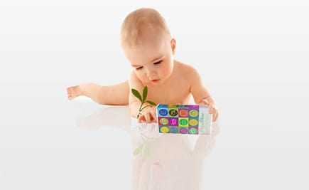 Infant exploring a colorful toy with numbers and letters while holding a small plant. - Olive Oil Times