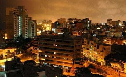 A nighttime view of Lima, Peru, showcasing buildings and city lights under a cloudy sky. - Olive Oil Times