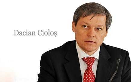Dacian Cioloș, a man in a suit with a red tie, seated and looking serious. - Olive Oil Times
