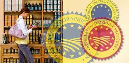 Individual standing in front of a shelf filled with olive oil bottles while using a smartphone. - Olive Oil Times