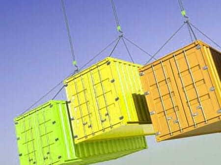 Three shipping containers in yellow, green, and orange suspended from cables against a blue sky. - Olive Oil Times