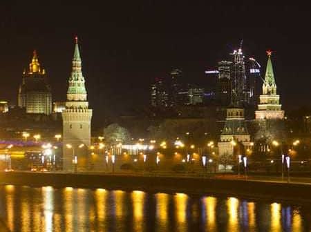 Night view of the Moscow Kremlin with illuminated towers and buildings along the river. - Olive Oil Times