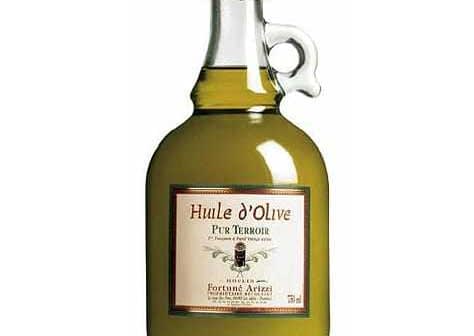 Glass bottle of Huile d'Olive Pur Terroir olive oil with a green liquid inside. - Olive Oil Times
