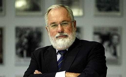 A man with a white beard wearing glasses and a suit, standing with arms crossed. - Olive Oil Times