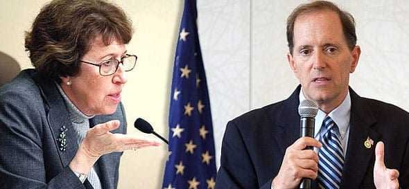 Two individuals in a discussion, one speaking into a microphone and the other gesturing with their hand. - Olive Oil Times