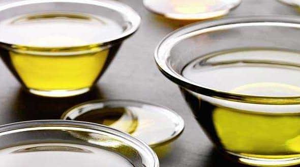 Several glass bowls containing olive oil, varying in size and filled with a golden liquid. - Olive Oil Times