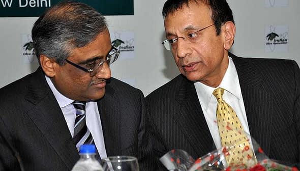 Two men in business attire engaged in a conversation at a formal event. - Olive Oil Times