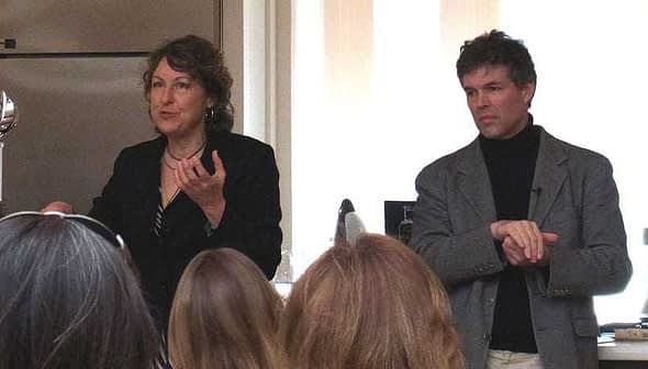 Two presenters speaking during a cooking demonstration in a kitchen setting. - Olive Oil Times