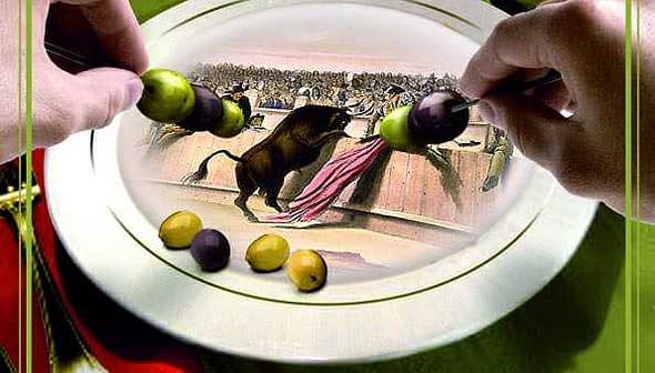 Hands holding a plate with olives and an illustration of a bullfight scene. - Olive Oil Times