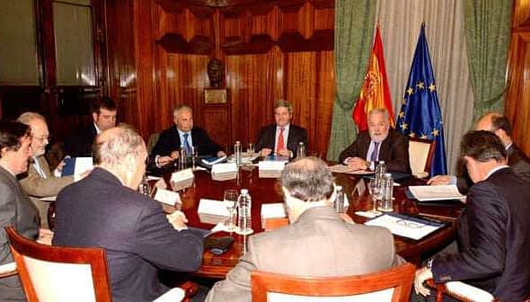 Group of officials seated around a large conference table during a meeting. - Olive Oil Times