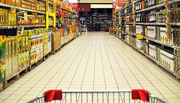 A grocery store aisle displaying various olive oil products on shelves. - Olive Oil Times