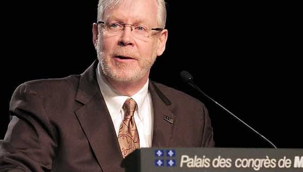 A man with glasses speaking at a podium with a sign that reads 'Palais des congrès de Montréal'. - Olive Oil Times