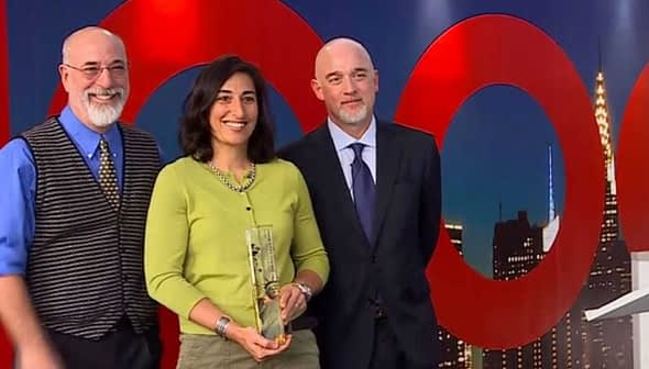 Three individuals at an award ceremony, one holding a trophy and smiling. - Olive Oil Times