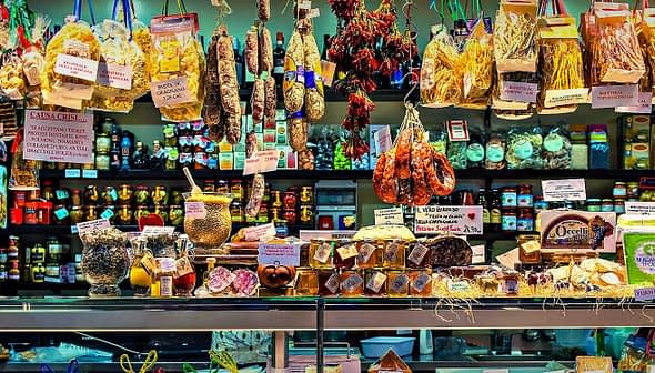 A market display featuring various food products including pasta, meats, and preserves. - Olive Oil Times