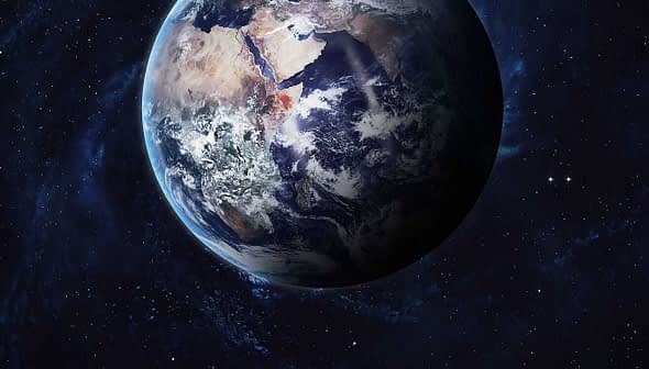 A detailed view of Earth from space, showing landmasses and oceans against a dark background. - Olive Oil Times