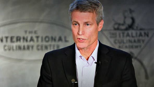 A man delivering a presentation at the International Culinary Center with a microphone attached. - Olive Oil Times