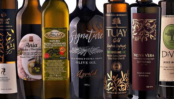 Assorted olive oil bottles displayed in a row with different labels and designs. - Olive Oil Times