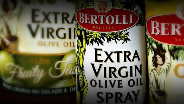 Three bottles of Bertolli extra virgin olive oil, including a spray option and fruity taste variant. - Olive Oil Times