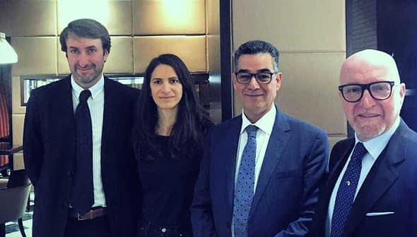 Four individuals in formal attire standing together in an indoor setting. - Olive Oil Times