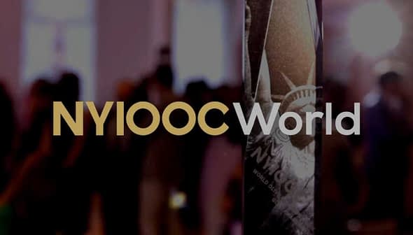 A crystal trophy with the inscription 'NYIOOC World' prominently displayed in a blurred background. - Olive Oil Times