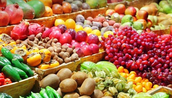 Colorful assortment of fresh fruits and vegetables arranged in baskets at a market. - Olive Oil Times
