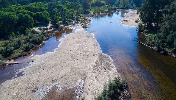 Aerial view of a river featuring sandbanks and surrounding vegetation. - Olive Oil Times