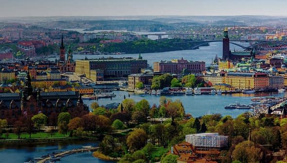 Aerial view of Stockholm showcasing the cityscape, waterways, and greenery in the foreground. - Olive Oil Times