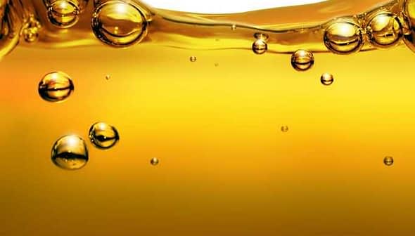 Close-up image of olive oil with bubbles suspended in the liquid. - Olive Oil Times