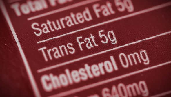 Close-up of a nutrition label indicating 5g of trans fat content. - Olive Oil Times